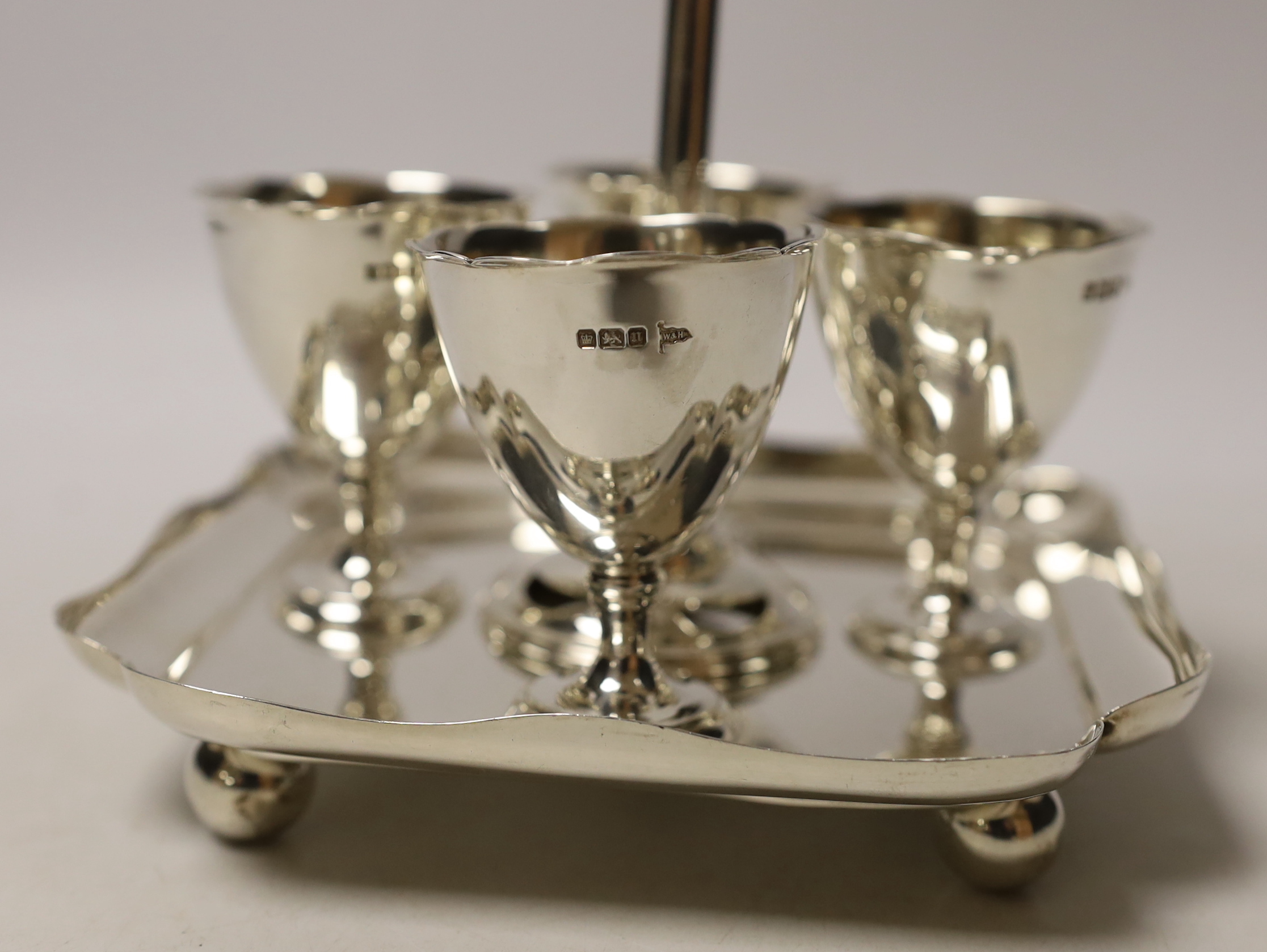 An Edwardian silver egg cruet, with loop handle and four cups, Walker & Hall, Sheffield, 1905/6, height 19.3cm, 17.2oz.